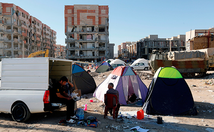 Iranians camp in tents outside damaged buildings in the town of Sarpol-e Zahab on November 14, 2017, following a 7.3-magnitude earthquake.