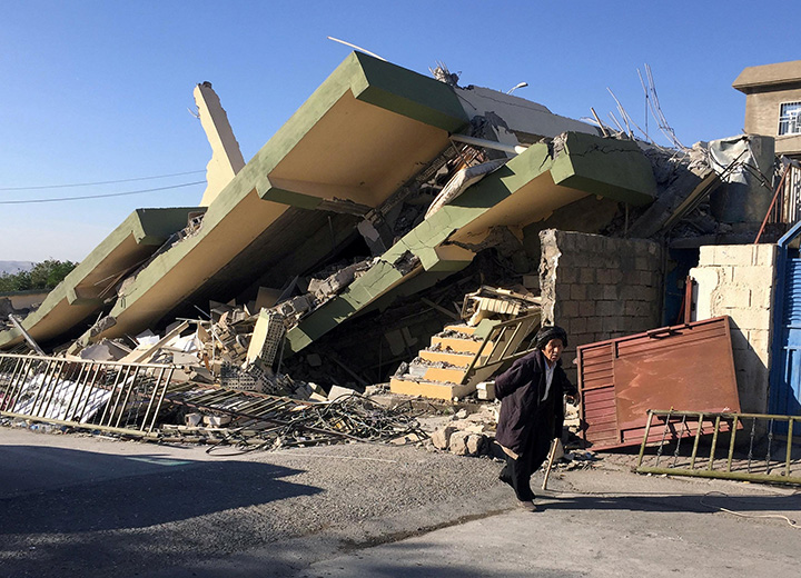 A man walks past a damaged building following an earthquake in Darbandikhan, Iraq, November 13, 2017.