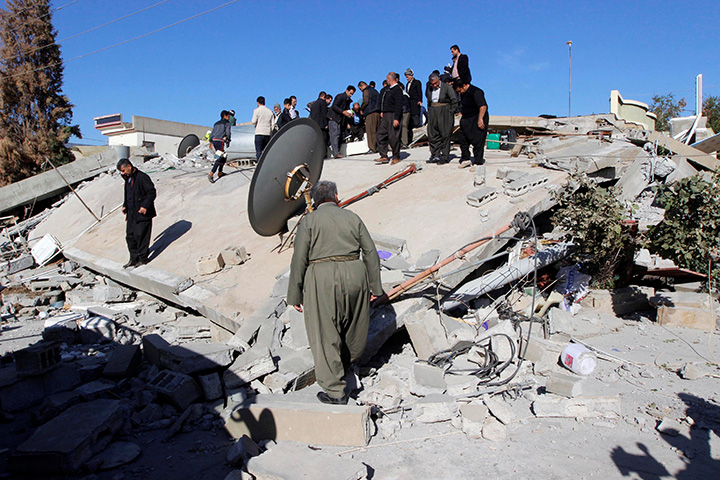 Residents look at a damaged building following an earthquake in the town of Darbandikhan, Iraq November 13, 2017.