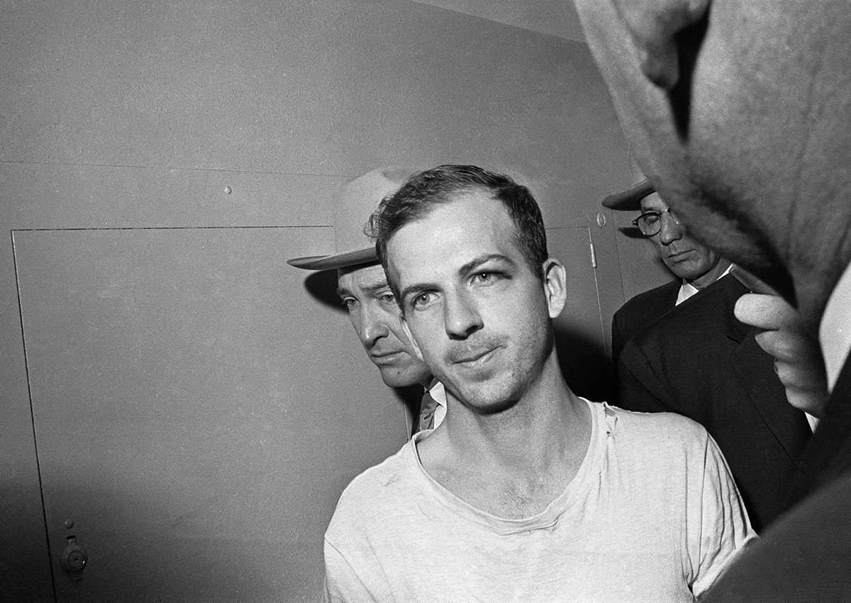 In this Nov. 23, 1963 file photo, Lee Harvey Oswald is led down a corridor of the Dallas police station for another round of questioning in connection with the assassination of U.S, President John F. Kennedy. Oswald, who denied any involvement in the shooting, was formally charged with murder.