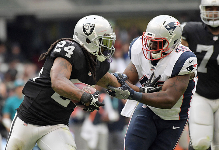 Oakland Raiders running back Marshawn Lynch stiff arms New England Patriots linebacker David Harris during an NFL International Series game at Estadio Azteca. 