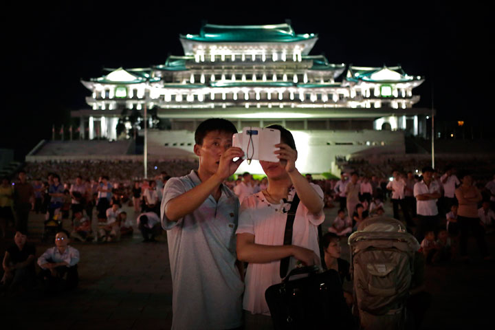 In this Sunday, July 27, 2014, file photo, a North Korean couple use a smartphone to photograph fireworks in at Kim Il Sung Square in Pyongyang, North Korea.