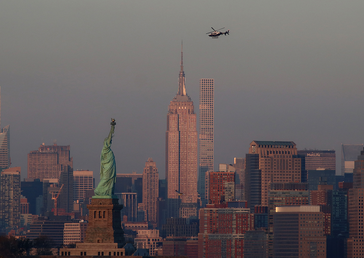 An NYPD helicopter passes over the skyline of New York City at sunset on November 12, 2017 as seen from Bayonne, New Jersey. 