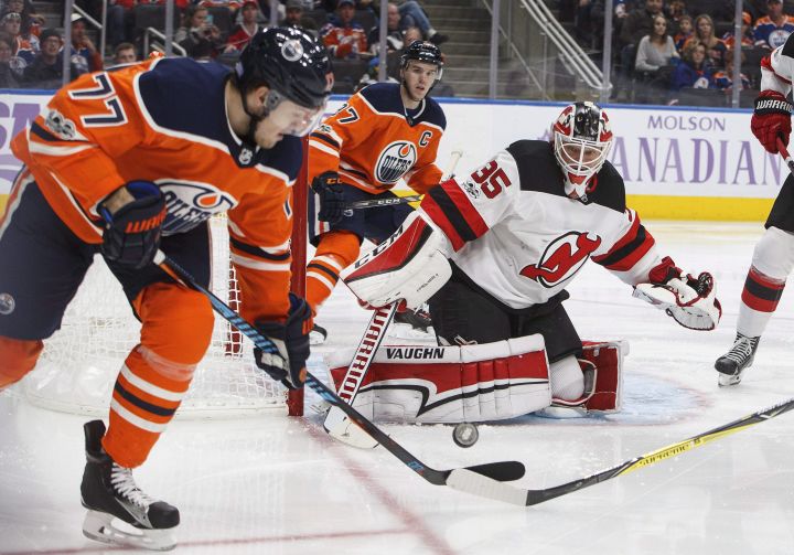 New Jersey Devils goalie Cory Schneider (35) makes the save as Edmonton Oilers' Oscar Klefbom (77) picks up the rebound during second period NHL action in Edmonton on Friday, November 3, 2017. 