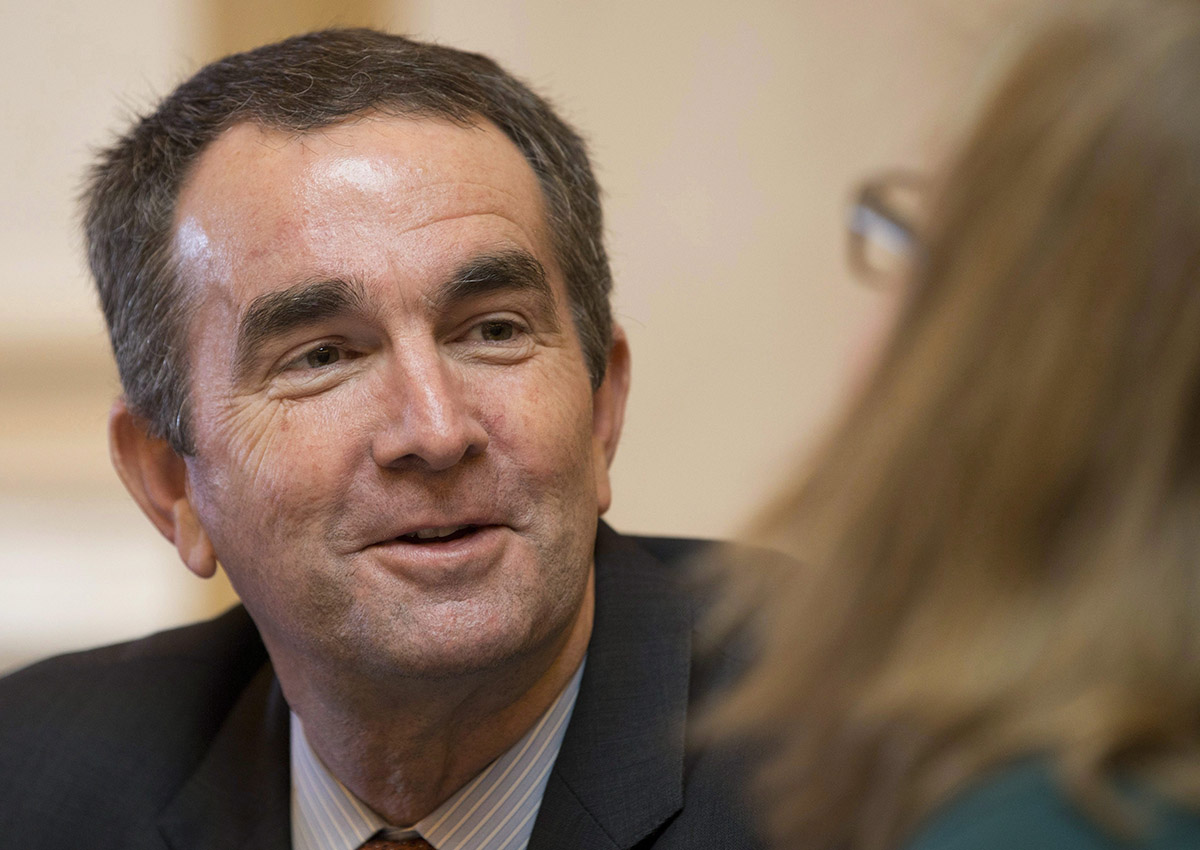 In this Jan. 26, 2016, file photo Virginia Lt. Gov., and Democratic candidate for Governor, Ralph Northam, left, talks with Senate Chief Deputy Clerk, Tara Perkinson, right, prior to the start of the Senate session at the Capitol in Richmond, Va.