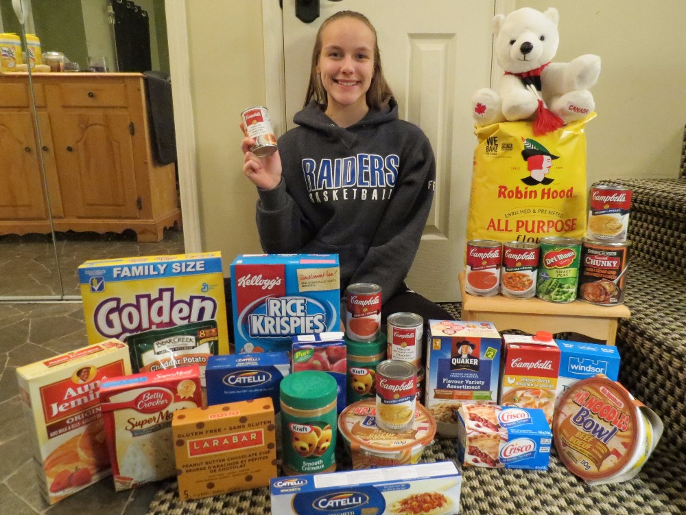 Skylar Ferguson poses with some food donated through her initiative. 