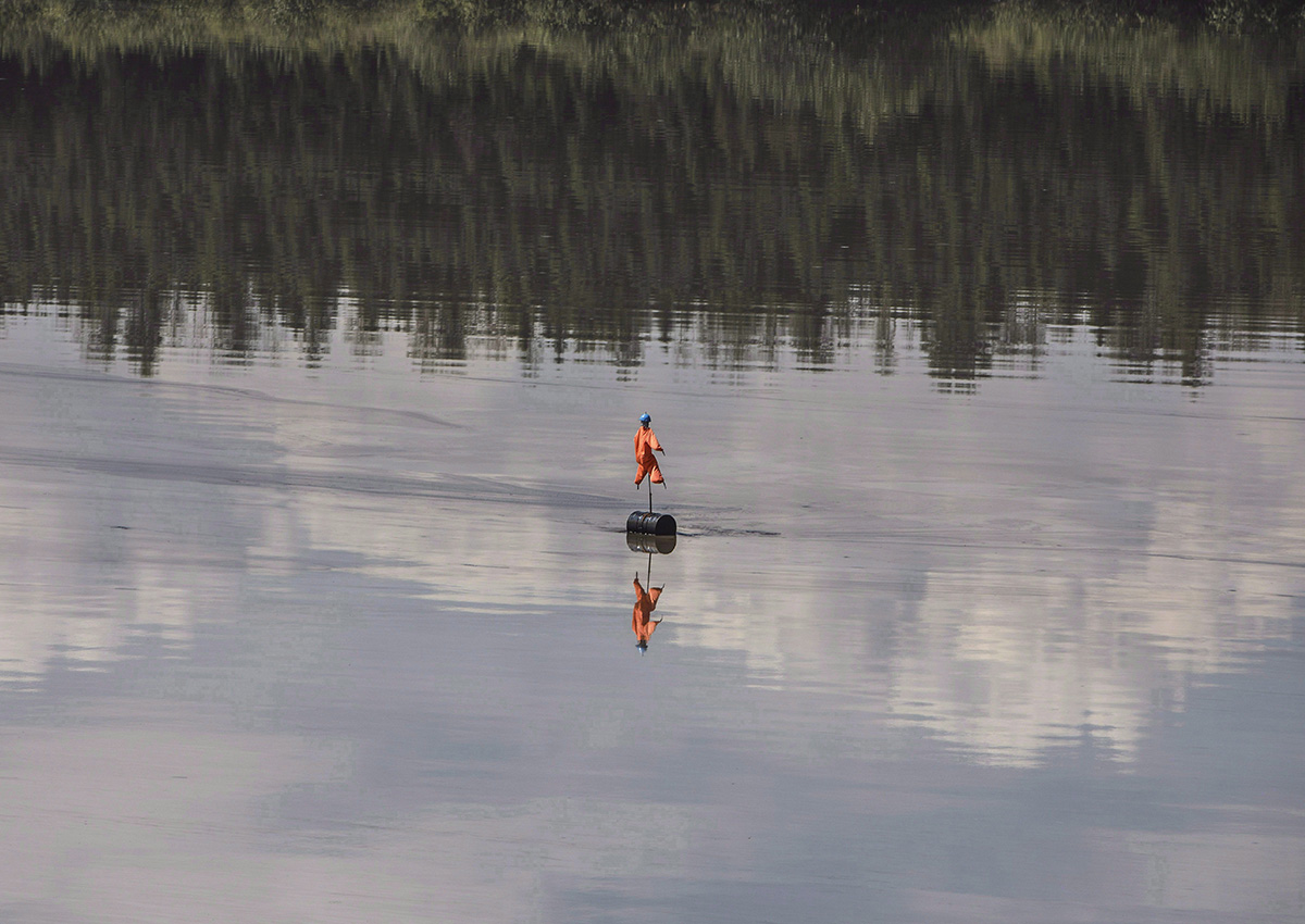 A scarecrow floats in a Suncor oil sands tailings pond, to keep birds from landing, in Fort McMurray, Alta., on Monday, June 13, 2017. The Canadian government says it lacked the scientific evidence to determine if oilsands tailings ponds were leaking into waterways and hurting fish. 