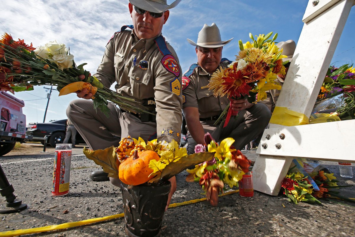 Texas State Troopers pick up flowers left for a memorial to move them out of the street near the church while investigators work at the scene of a mass shooting at the First Baptist Church in Sutherland Springs, Texas, USA, 06 November 2017.