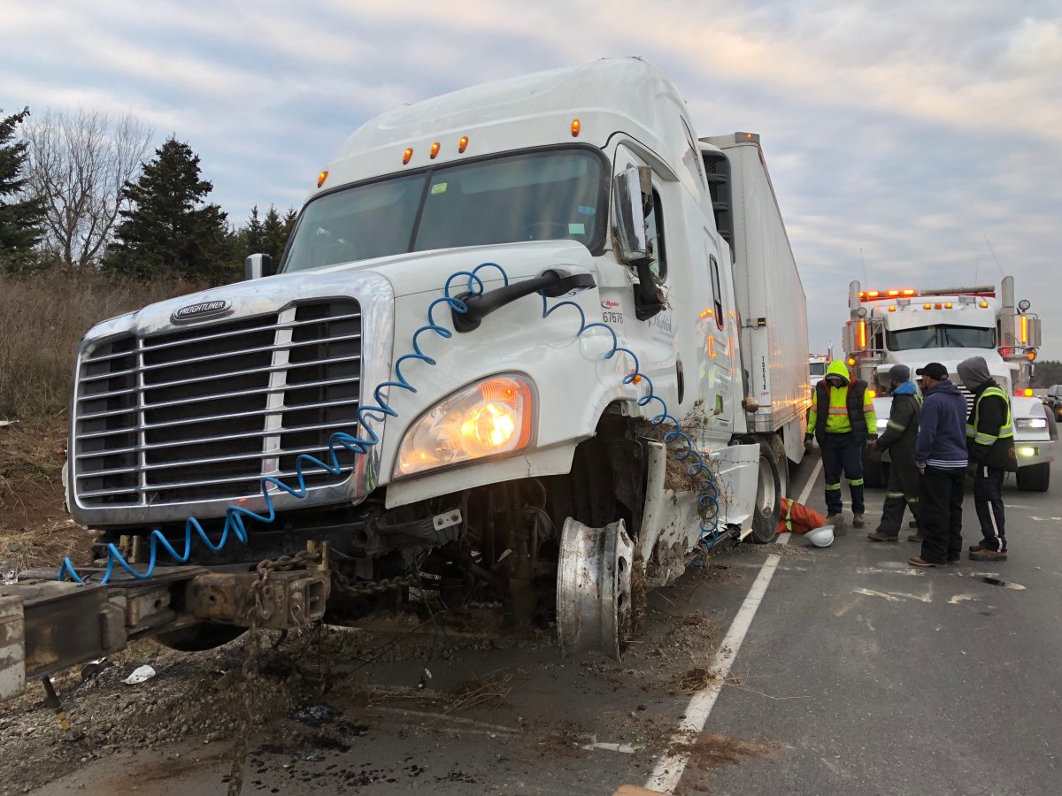 A transport truck rolled into the ditch on Highway 401 near Guelph Line on Thurs., Nov. 23, 2017. A tow truck operator was seriously injured during the cleanup. Andrew Collins/Global News.