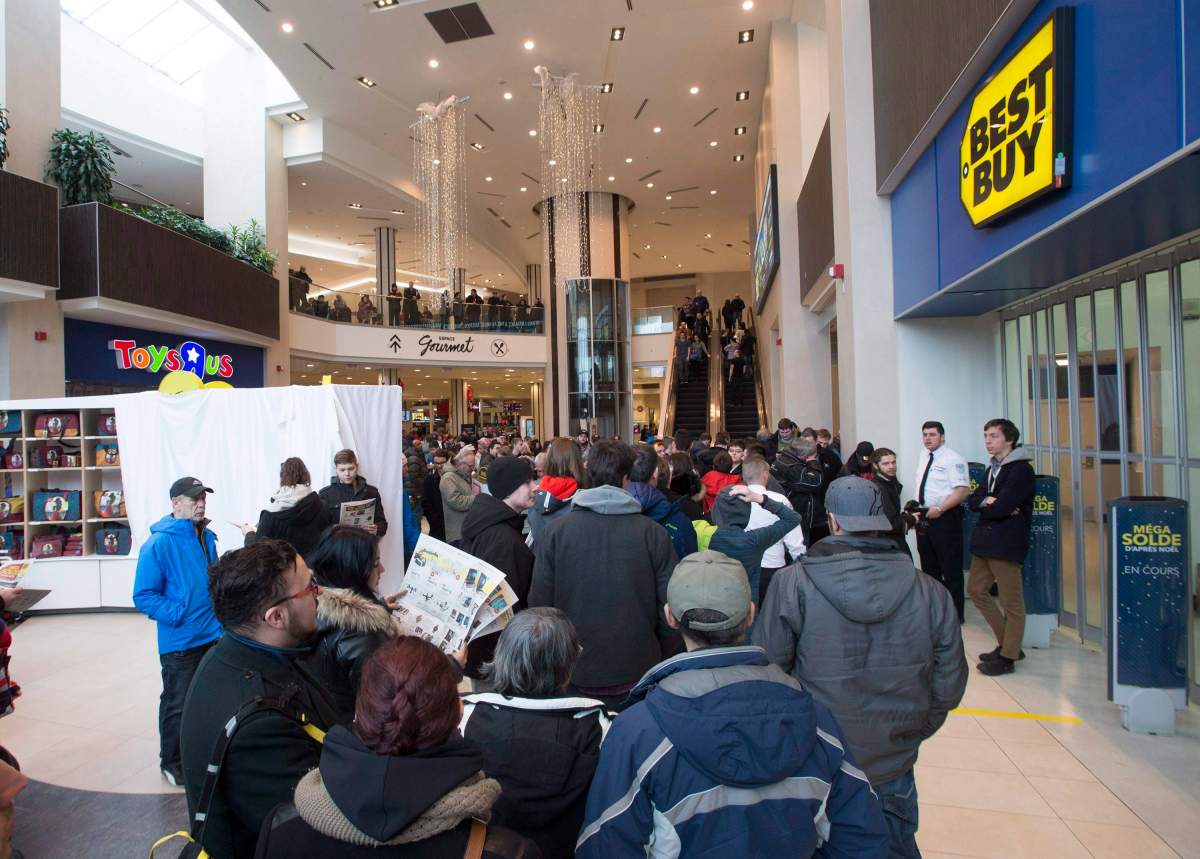 Shoppers wait in line before the opening of a Best Buy in Quebec City on Boxing Day, Dec. 26, 2016. 