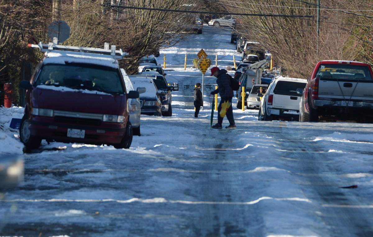 A man navigates an ice-covered street in Vancouver, Tuesday, Jan. 3, 2017.