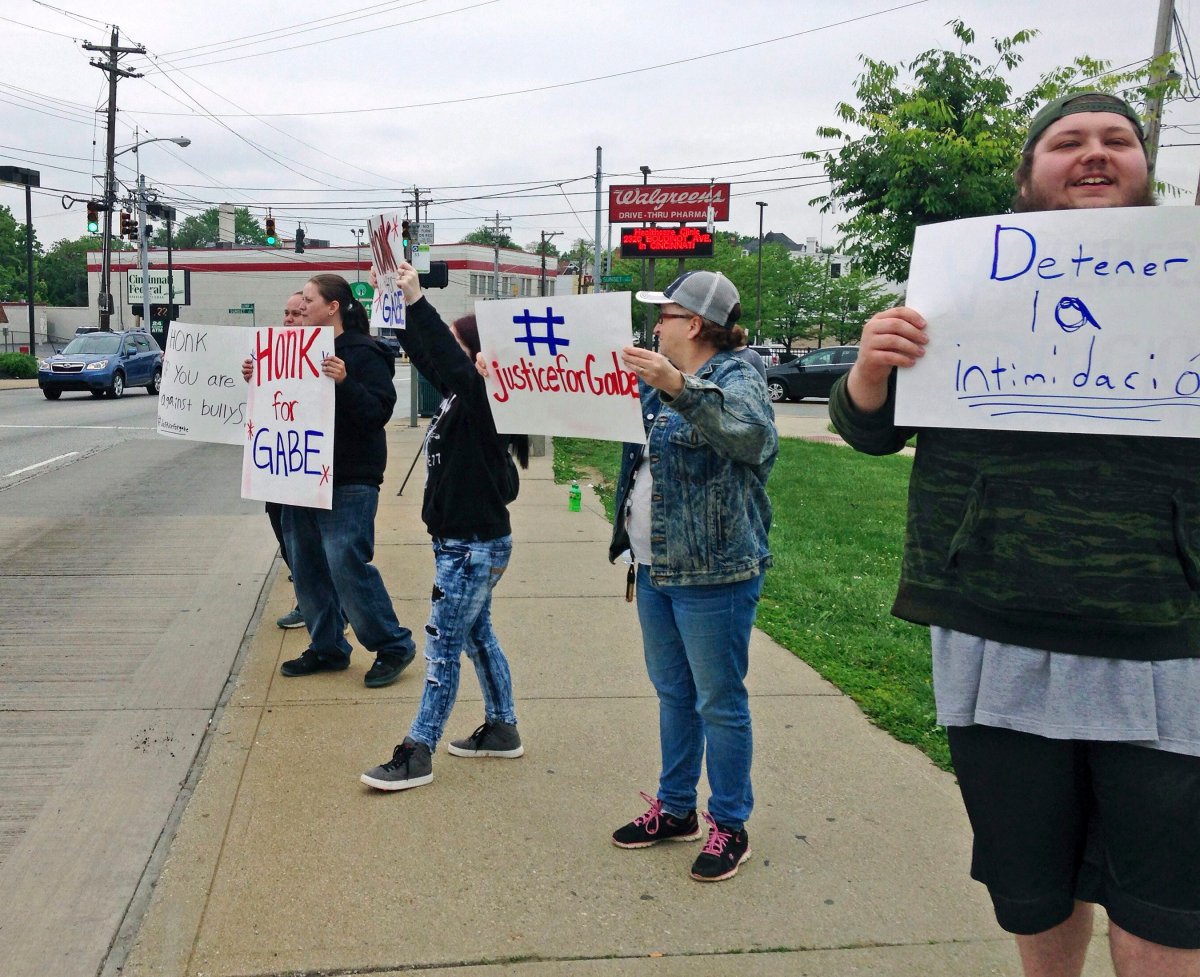 Parents and other demonstrators hold signs against bullying and in memory of Gabriel Taye, an 8-year-old boy who killed himself in January 2017 two days after being knocked unconscious by another Carson School student, on Friday, May 12, 2017, outside the elementary school in Cincinnati. 