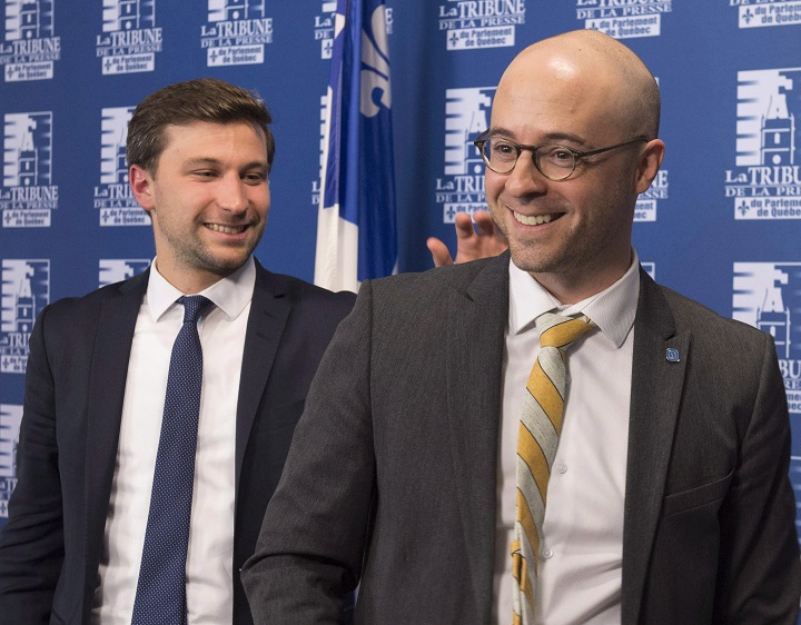 Quebec Solidaire MNA Gabriel Nadeau-Dubois, left, taps on Option nationale leader Sol Zanetti's shoulder at the end of a news conference, Thursday, October 5, 2017 in Quebec City. Both parties voted in favour of merging. Monday, Dec. 11, 2017.
