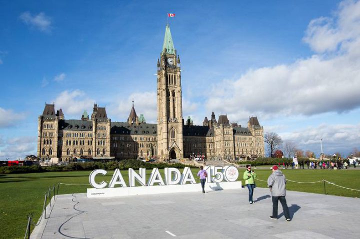 Tourists take their picture at the Canada 150 sign on Parliament Hill in Ottawa, Ontario on Monday, Oct. 30, 2017. 