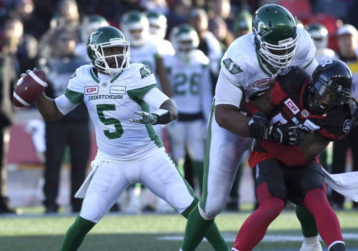 Saskatchewan Roughriders quarterback Kevin Glenn (5) throws the ball as teammate Thaddeus Coleman (68) controls Ottawa Redblacks' Jonathan Newsome (43) during second half Eastern semifinal CFL action in Ottawa on Sunday, Nov. 12, 2017. 