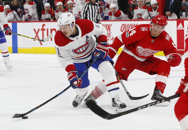Montreal Canadiens right wing Brendan Gallagher (11) shoots as Detroit Red Wings right wing Gustav Nyquist (14) defends in the third period of an NHL hockey game Thursday, Nov. 30, 2017, in Detroit. Gallagher scored on the shot..