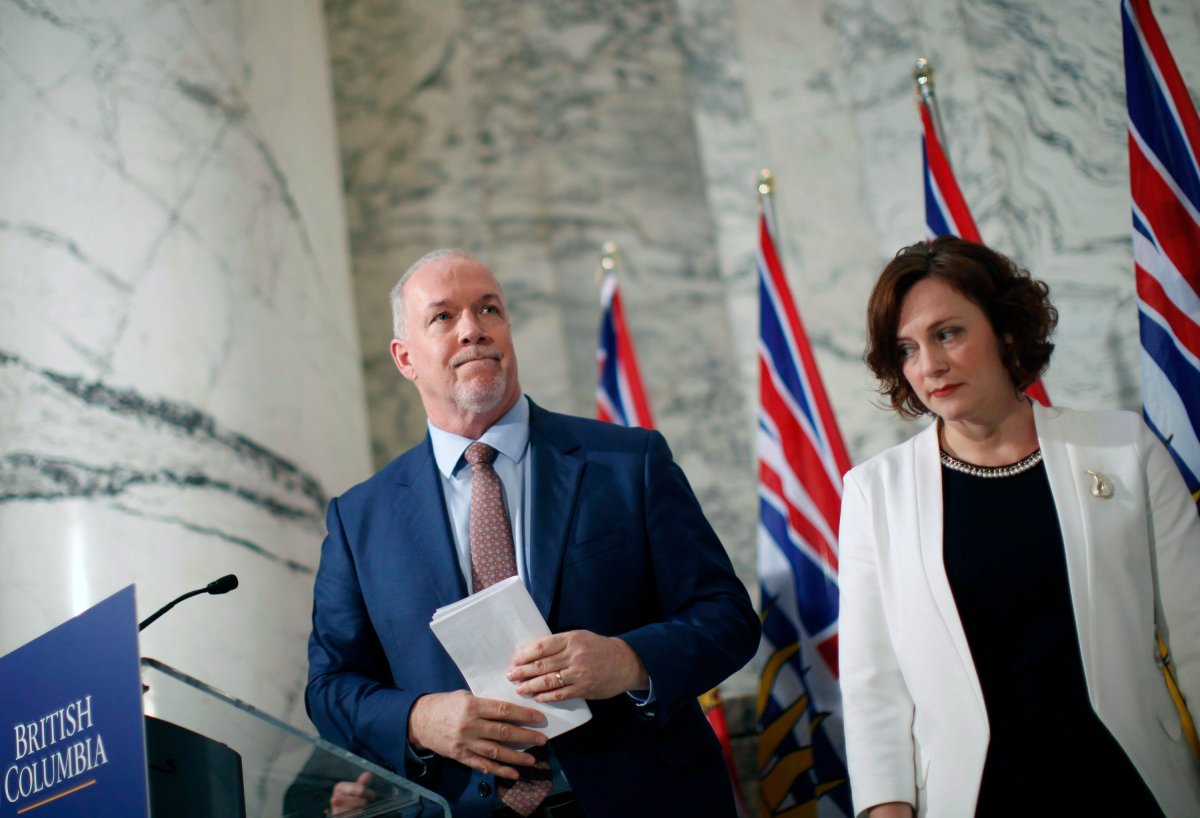 Premier John Horgan is joined by Minister of Energy Michelle Mungall after giving the green light on continuing construction on the controversial Site C Dam project during a press conference in Victoria, B.C., on Monday, December 11, 2017. 