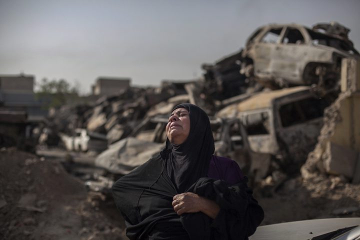 In this Oct. 9, 2017, photo, Fatima Ahmed Aswad cries as the body of her 15-year-old daughter Sana is exhumed in Mosul for forensic investigation in order to receive a death certificate. The girl died from a mortar attack in the final battle to drive out Islamic State extremists, among between 9,000 and 11,000 civilians killed in the fighting. 