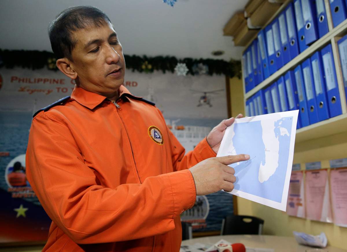 Coast guard spokesman Armand Balilo points at an area on the map where the passenger vessel Mercraft 3 reportedly began sinking as he talks to reporters in Manila, Philippines on Thursday, Dec. 21, 2017. 