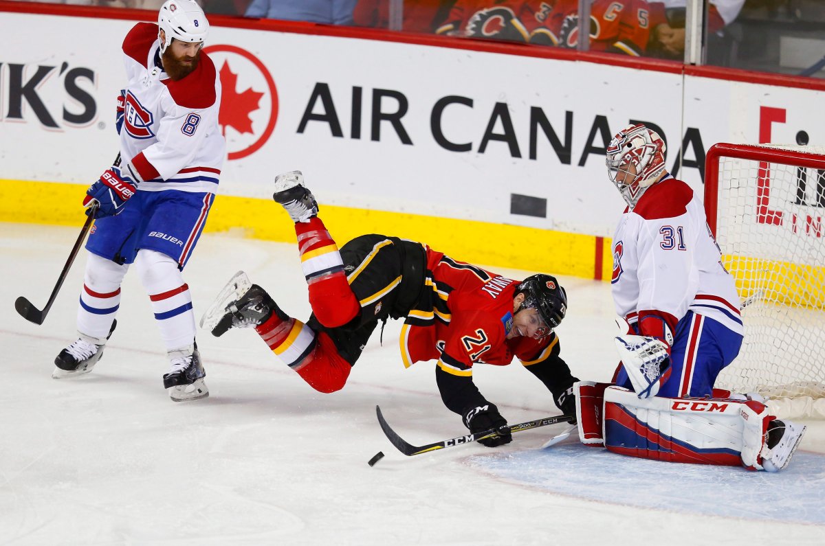 Montreal Canadiens' Jordie Benn (8) sends Calgary Flames' Garnet Hathaway (21) flying into Canadiens goalie Carey Price during second period NHL hockey action in Calgary on Friday, Dec. 22, 2017. 
