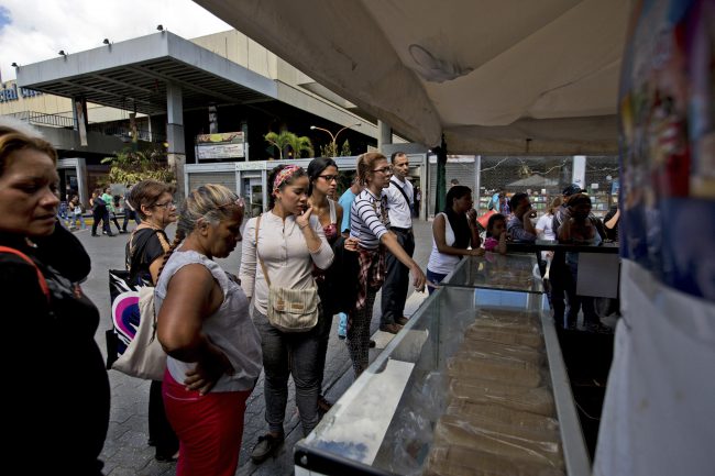 Customers ask for the price of a typical Venezuelan Christmas staple known as "Pan de Jamon" or ham bread, at a Christmas fair in Caracas, Venezuela, Dec. 22, 2017.