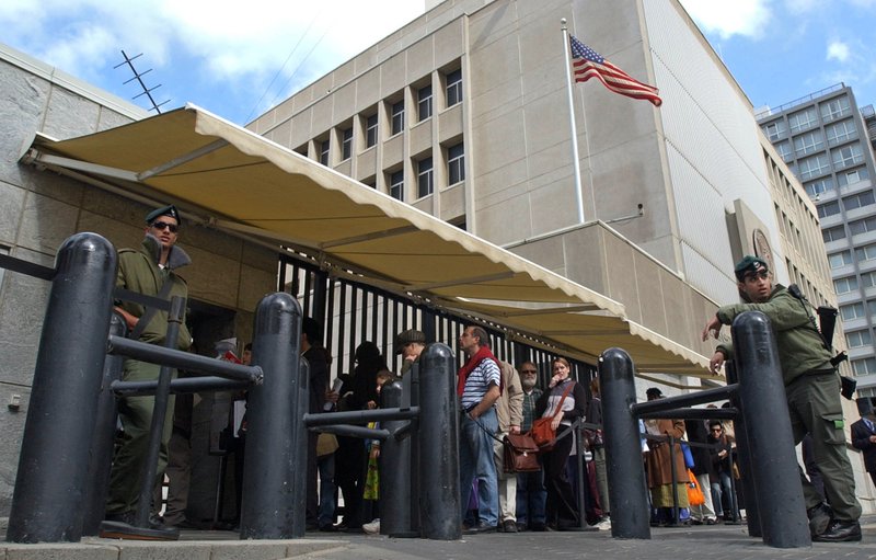 In this March 17, 2003, file photo, an Israeli border policemen guards the U.S. Embassy in Tel Aviv as other Israelis line up for U.S. visas. U.S. officials say U.S. President Donald Trump is poised to again delay his campaign promise to move the U.S. Embassy in Israel from Tel Aviv to Jerusalem. 