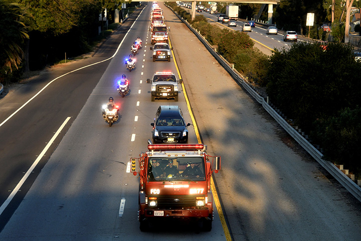 A procession of firefighting vehicles passes through Santa Paula, while carrying the body of a fellow firefighter who was killed battling the Thomas wildfire near Fillmore, California, December 14, 2017.
