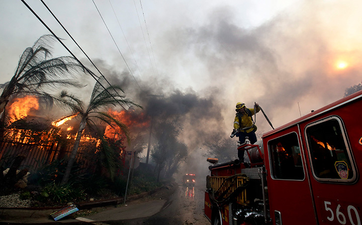 A Los Angeles County firefighter prepares to battle a hot spot on the Creek Fire in the Lake View Terrace area of Los Angeles, Tuesday, Dec. 5, 2017.