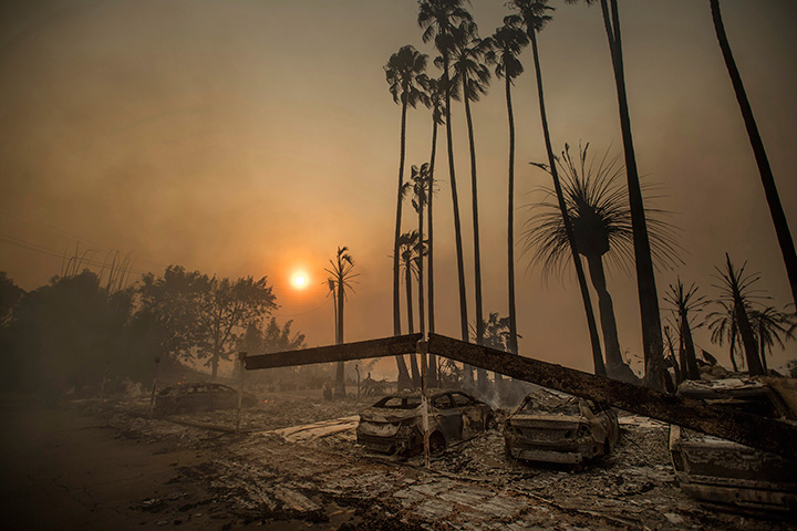 Smoke rises behind a levelled apartment complex as a wildfire burns in Ventura, Calif., on Tuesday, Dec. 5, 2017.