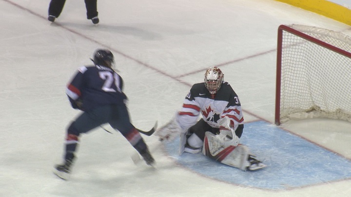 Team Canada goalie Geneviève Lacasse makes a glove save against the United States.