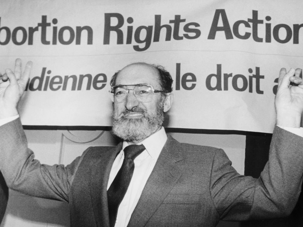 Dr. Henry Morgentaler raises his arms in victory at a news conference in Toronto, Ont., Jan. 28, 1988. This January marks 30 years since the Supreme Court of Canada struck down the country's abortion law as unconstitutional.