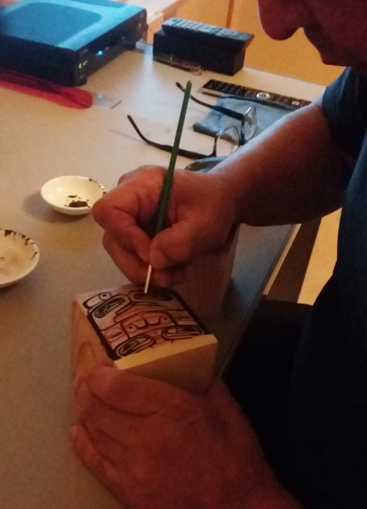 Andy Wilson of the Haida First Nation paints a delicate design on a traditional Haida bentwood box in this undated handout photo.