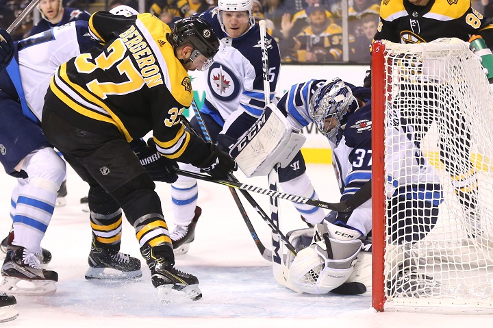 Connor Hellebuyck of the Winnipeg Jets saves a shot on goal from Patrice Bergeron of the Boston Bruins during the first period at TD Garden on Dec. 21 in Boston.