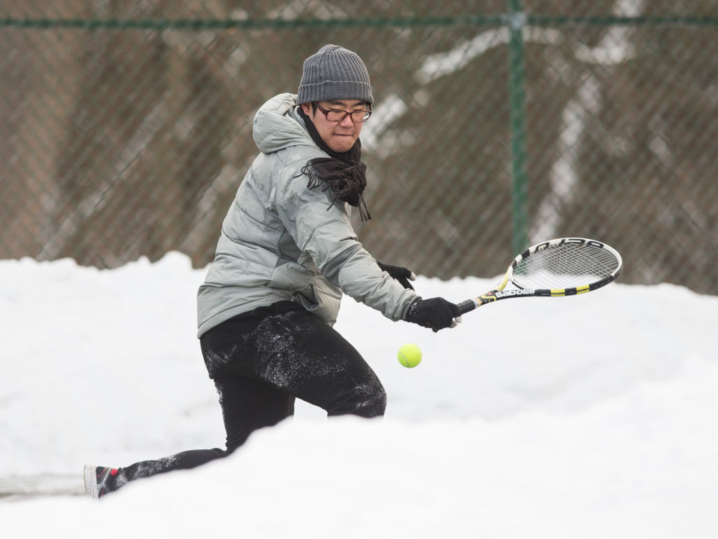 TORONTO – Despite the frigid temperature in Toronto, Dong Jae Kim (in photo) and his father Steve Kim took advantage of the cleared tennis courts at High Park to play a game of tennis for a $5 prize on Dec. 30, 2017.