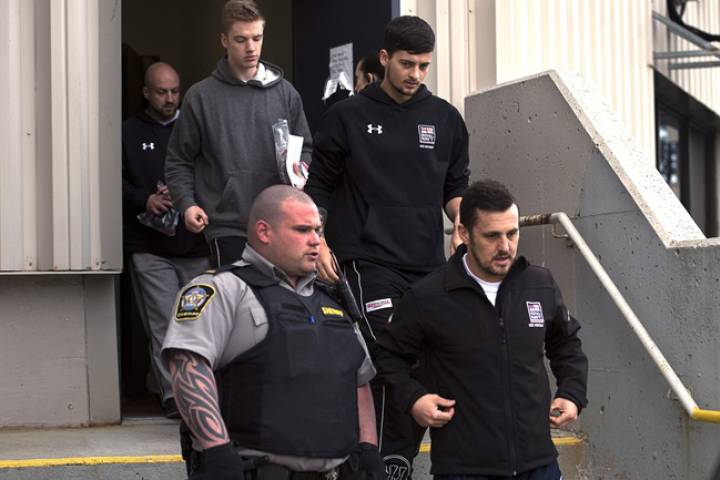 Darren Smalley, Craig Stoner, Joshua Finbow and Simon Radford, left to right, members of the British navy in Nova Scotia for a hockey tournament, are released from provincial court in Dartmouth, N.S., on Monday, April 20, 2015.
