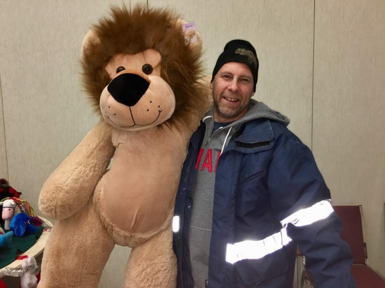 Salvation Army client Roger Tremblay picks up a gift during hamper distribution.
