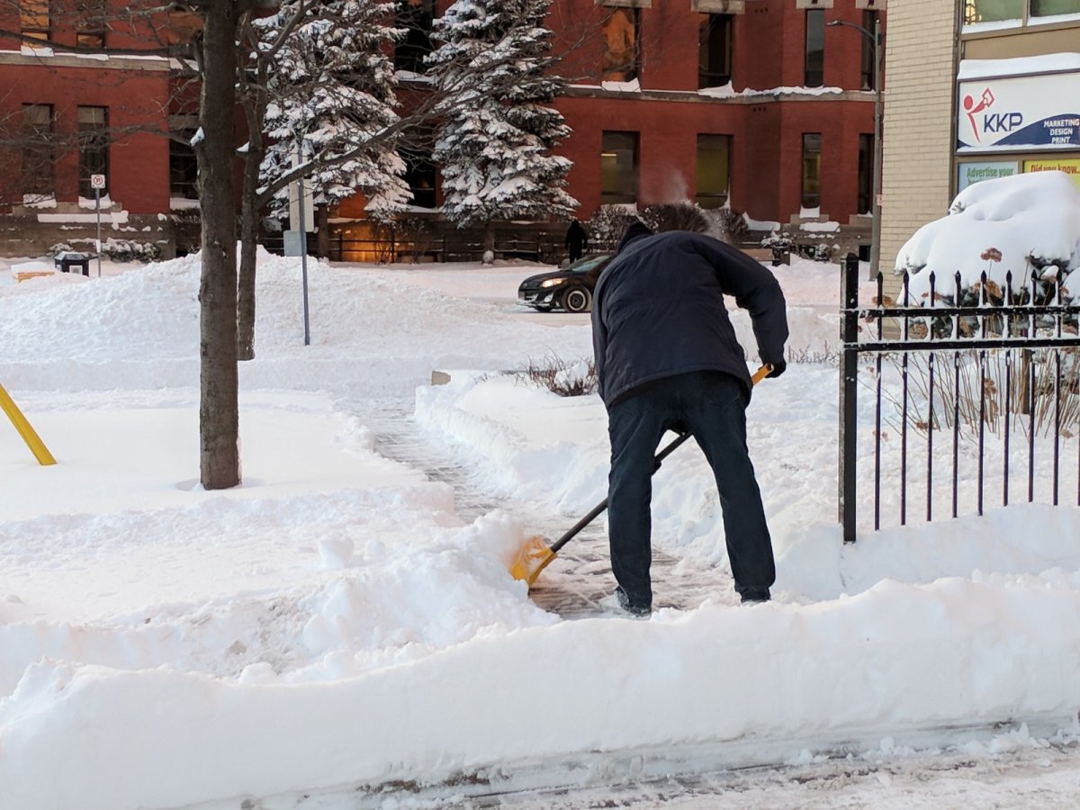 A Londoner shovels the sidewalk in Dec. 2017.