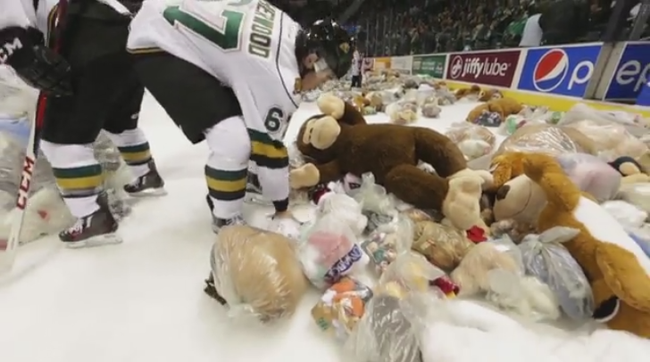 Knights players help collect the stuffed animals tossed during the 15th annual Teddy bear Toss.