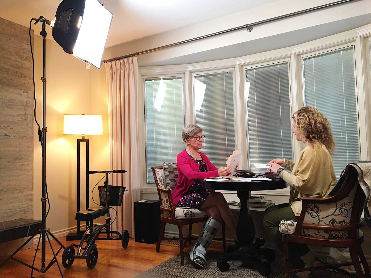 Volunteer Anne Lennox and creator Barb Brittain-Marshall review stacks of cards.