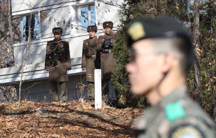 In this Nov. 27, 2017, file photo, North Korean soldiers look at the South side as a South Korean stands guard near the spot where a North Korean soldier crossed the border on Nov. 13 at the Panmunjom, in the Demilitarized Zone, South Korea.