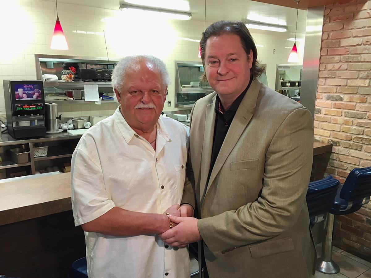 Earl Barish and Noel Bernier shake hands after Bernier bought Barish’s shares of Salisbury House.