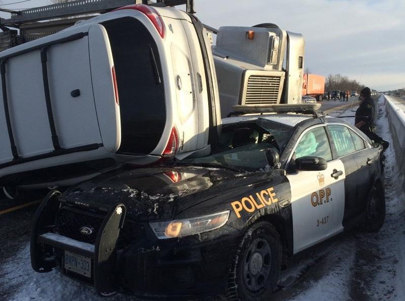 A tractor-trailer lost control and jackknifed, striking the police cruiser.