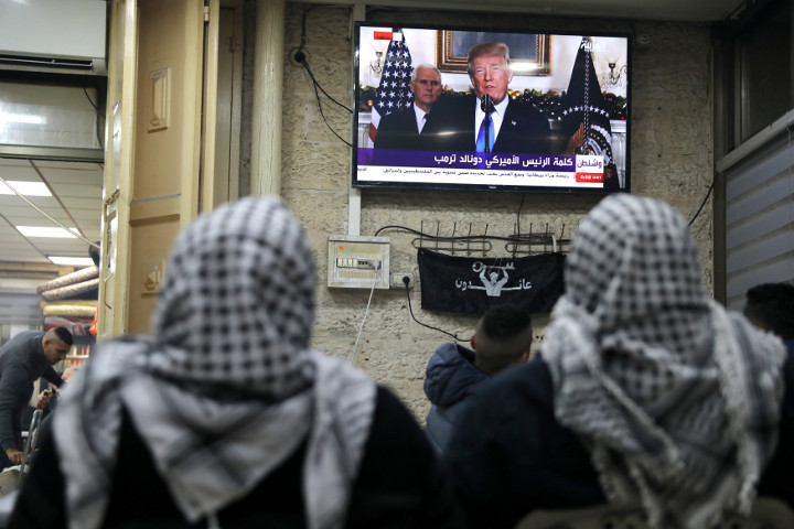 Palestinians watch a televised broadcast of U.S. President Donald Trump delivering an address where he announced that the United States recognizes Jerusalem as the capital of Israel, in Jerusalem's Old City on Dec. 6, 2017.