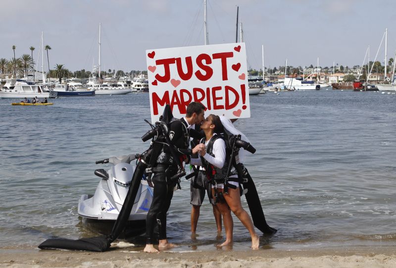 Grant Engler and his new wife, Amanda Engler, kiss after arriving back on shore following their wedding dance over the water in jetpack suits Thursday, Aug. 23, 2012 in Newport Beach, Calif.