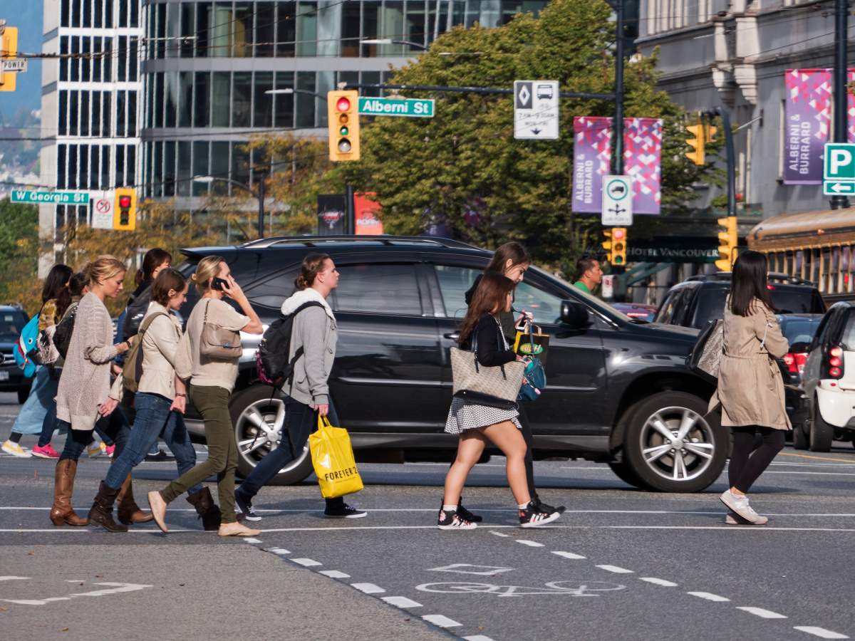Pedestrians cross Burrard Street at Robson Street, downtown Vancouver, October 7, 2014. 
