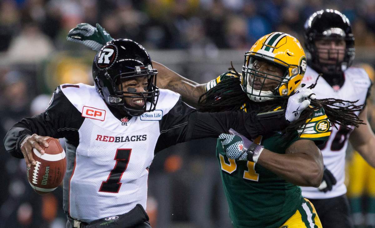 Edmonton Eskimos' Marcus Howard tries to grab Ottawa Redblacks' quarterback Henry Burris during the 103rd Grey Cup in Winnipeg, Man. Sunday, Nov. 29, 2015. 