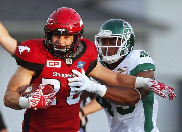 Calgary Stampeders' Rob Cote tries to break a tackle by Saskatchewan Roughriders' Jeff Knox Jr. during first half CFL football action in Calgary, Thursday, Aug. 4, 2016.