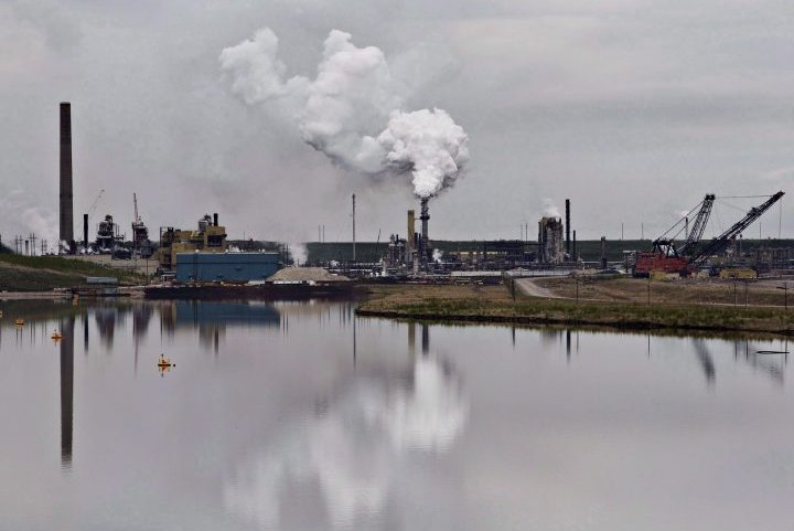The Syncrude oilsands extraction facility is reflected in a pond near the city of Fort McMurray, Alta., on June 1, 2014.