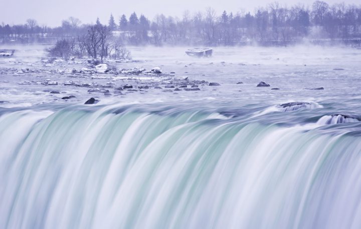 Mist rises around an old barge in the upper Niagara River near the brink of the falls in Niagara Falls, Ont.