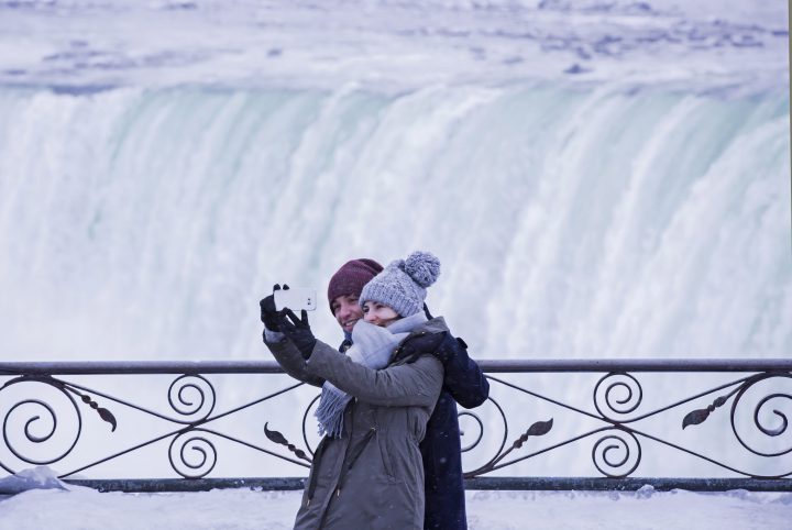 Visitors take photographs at the brink of the Horseshoe Falls in Niagara Falls, Ont.